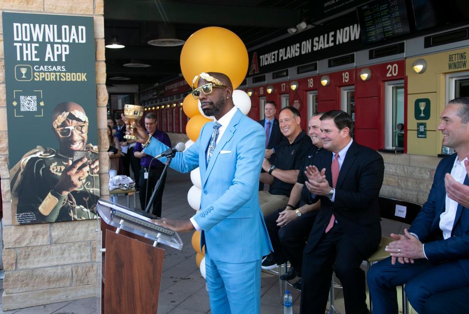 J.B. Smoove, star of the Caesars Sportsbook brand campaign, speaks, as, from left, former Diamondbacks player Luis Gonzalez, Diamondbacks President & CEO Derrick Hall, Governor Doug Ducey and Caesars co-Presidents Eric Hession, listen during an event marking the opening of the Caesars Sportsbook at Chase Field in Phoenix on the first day of sports betting on September 9, 2021. Chase Field is the first major league stadium to have sports betting.