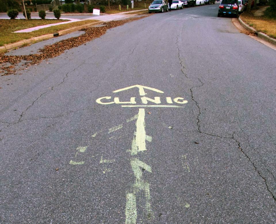 Directions to the clinic are painted on the street outside APWHC in Charlotte to avoid confusion with mobile crisis pregnancy centers stationed up the street from the clinic.&nbsp;
