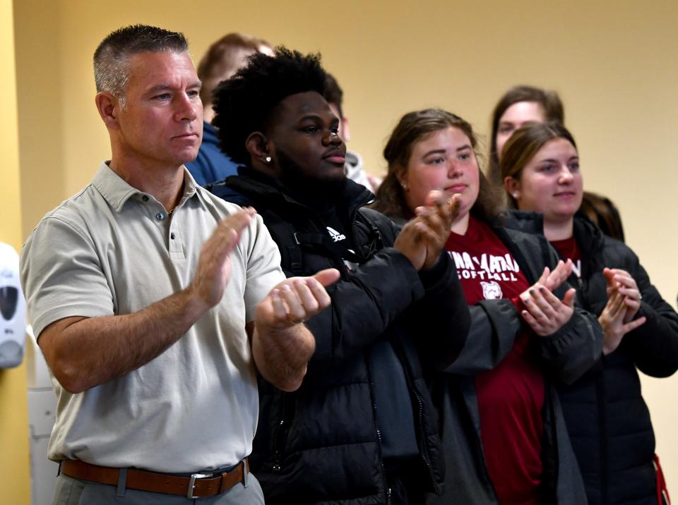 Dave McCauley, who coaches the Anna Maria College hockey team, applauds as the four players at Anna Maria College are honored for helping to rescue people from an apartment fire in Philadelphia when they were in town for the Super Bowl.
