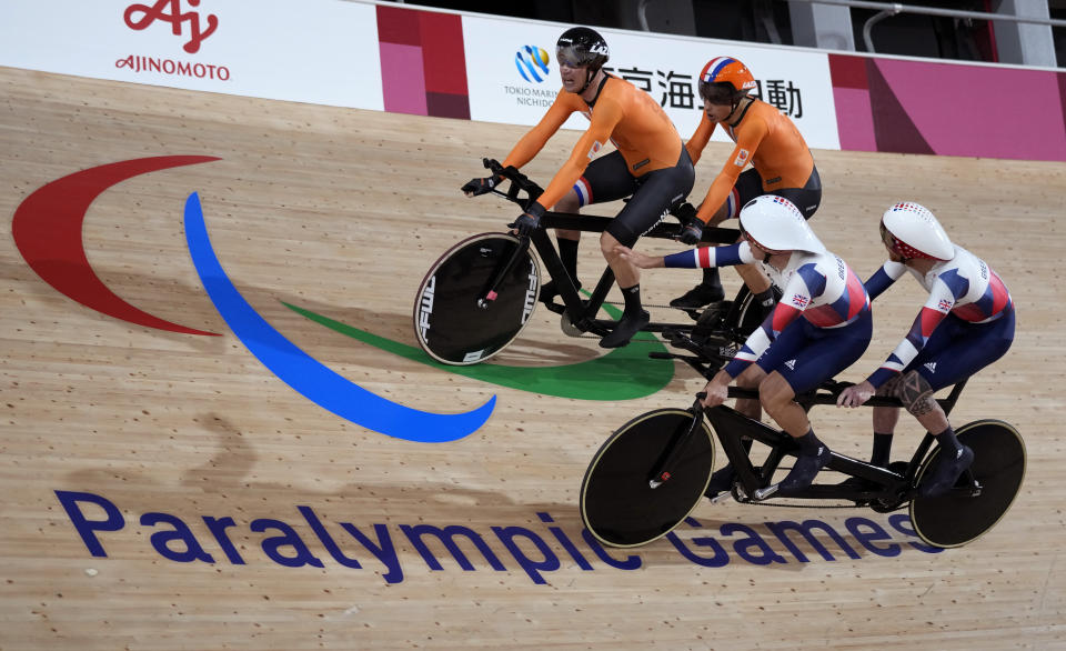 FILE - In this Aug. 25, 2021, file photo, Tristan Bangma, top right, and his pilot Patrick Bos, top left, of the Netherlands compete with Britain's Adam Duggleby, right, and his pilot Stephen Bate in the Cycling Track men's B 4000m Individual Pursuit final at the Tokyo 2020 Paralympic Games in Izu, Shizuoka prefecture, Japan. There are 4,403 Paralympic athletes competing in Tokyo, each with unique differences that have to be classified. Lines have to be draw, in the quest for fairness, to group similar impairments, or impairments that yield similar results. (AP Photo/Shuji Kajiyama)