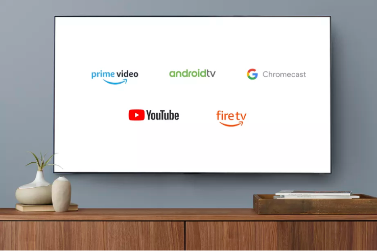 A wall mounted TV showing various logos, including Prime Video, AndroidTV, Chromecast, YouTube and FireTV.