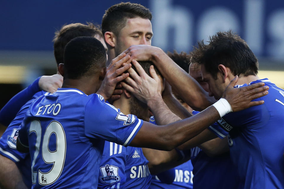 Chelsea's Eden Hazard, center, is mobbed by teammates as he celebrates his penalty goal and his third goal against Newcastle United during their English Premier League soccer match at Stamford Bridge, London, Saturday, Feb. 8, 2014. (AP Photo/Sang Tan)