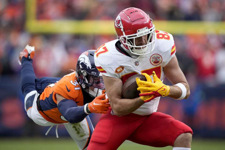 Kansas City Chiefs tight end Travis Kelce (87) catches a pass as Denver Broncos safety Justin Simmons (31) defends during the first half of an NFL football game Sunday, Oct. 29, 2023, in Denver. (AP Photo/David Zalubowski)