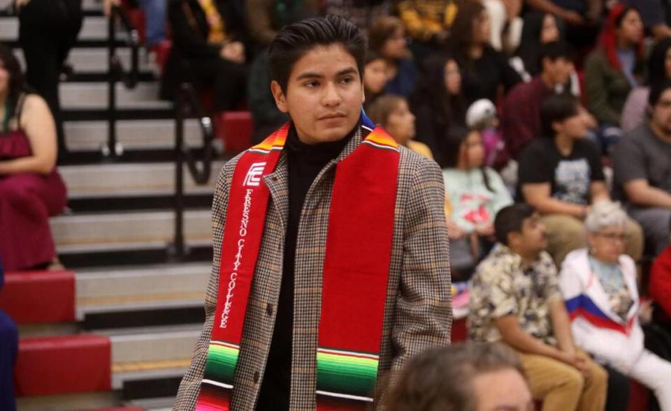 Graduate Alan Romero walks to his seat after getting his serape-themed sash at the 21st Latino Graduation Celebration at the college gym on May 6, 2023.