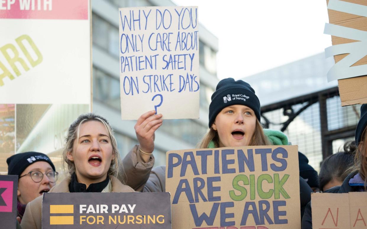 Demonstrators hold placards on a picket line during a strike by NHS nursing staff outside St. Thomas' Hospital in London - Paul Grover/Telegraph