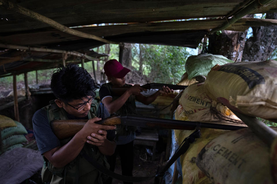 Zuan Vaiphei, 32, left, an armed tribal Kuki, keeps a watch on rival Meitei community bunkers, along a de facto frontline which dissect the area into two ethnic zones in Churachandpur, in the northeastern Indian state of Manipur on June 20. Two months ago, Vaiphei was teaching economics to students when the simmering tensions between the two communities exploded.<span class="copyright">Altaf Qadri—AP</span>