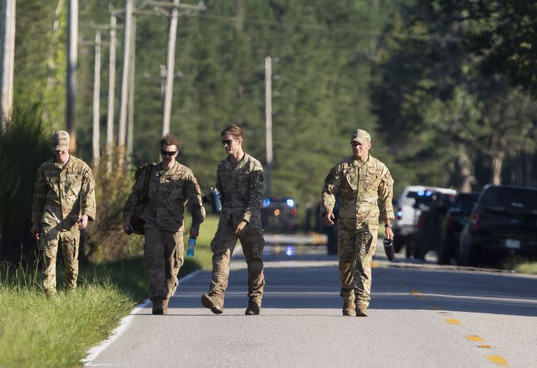 Airmen from Joint Base Charleston walk down Old Georgetown Road when setting up a base during the recovery process for an F-35 that crash landed in a field nearby in Williamsburg County, S.C., on Monday, Sept. 18, 2023. (Henry Taylor/The Post And Courier via AP)