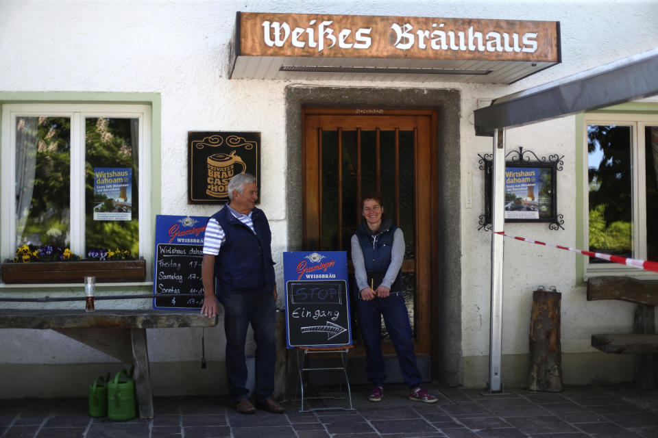 In this photo taken Thursday, May 7, 2020 brewery daughter Iris Detter and her father Karlmann stand in front of their 120 year old family brewery and traditional Bavarian restaurant in Altoetting, Germany. The 'Graminger Weissbraeu' brewery, which has been in the same family for a century, is preparing to welcome guests back to its restaurant for the first time in two months — with new rules and fears for the future. (AP Photo/Matthias Schrader)
