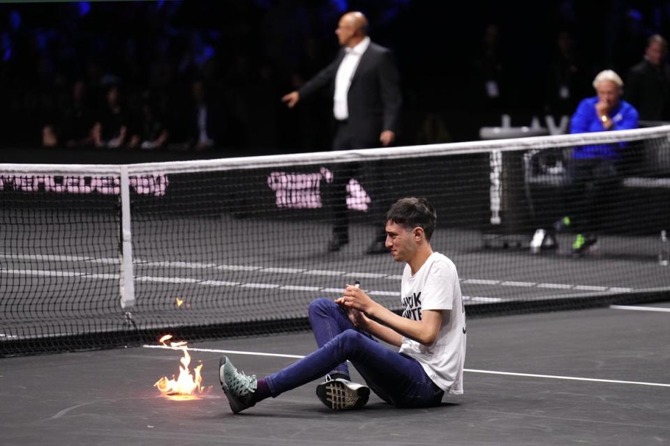 A protester lights a fire on the court at the Laver Cup (John Walton/PA) (PA Wire)