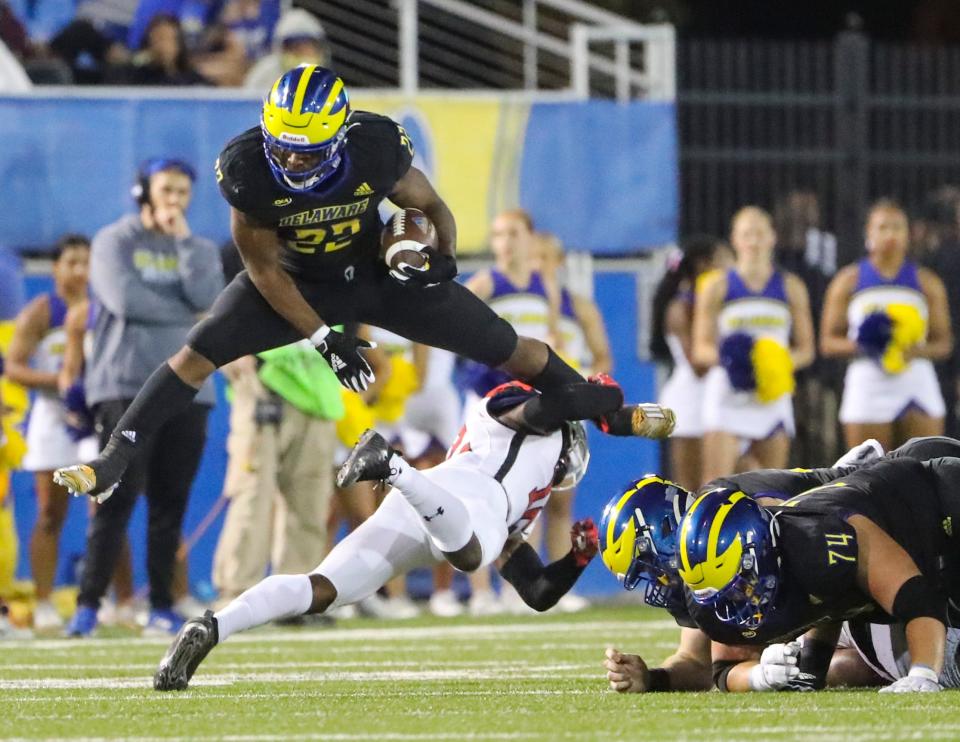 Delaware running back Khory Spruill gets some yards at the end of a run by vaulting his tackler in the fourth quarter of the Blue Hens' 27-10 win against St. Francis at Delaware Stadium Saturday, Sept. 11, 2021.