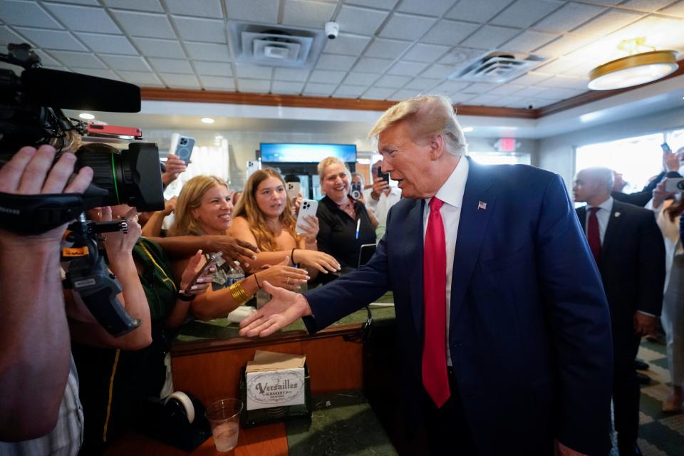 Former President Donald Trump greets supporters as he visits Versailles restaurant on Tuesday, June 13, 2023, in Miami. Trump's valet Walt Nauta, stands at right. Trump appeared in federal court Tuesday on dozens of felony charges accusing him of illegally hoarding classified documents and thwarting the Justice Department's efforts to get the records back.