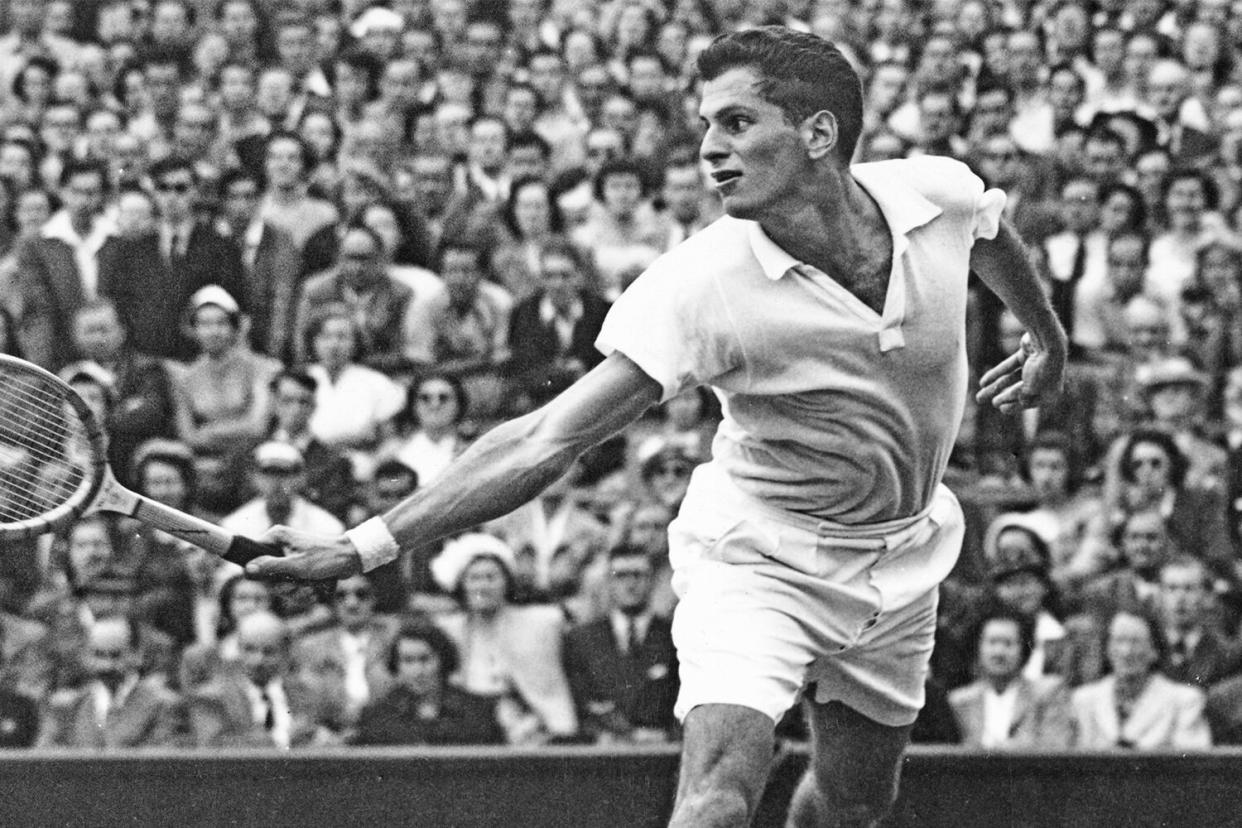 Dick Savitt of the United States reaches to make a back hand return to compatriot Herbie Flam during their Men's Singles Semi Final match at the Wimbledon Lawn Tennis Championship on 6th July 1951 at the All England Lawn Tennis and Croquet Club in Wimbledon in London, England. Dick Savitt won the match and championship 1-6, 15-13, 6-3, 6-2. ( Photo by Central Press/Hulton Archive/Getty Images )