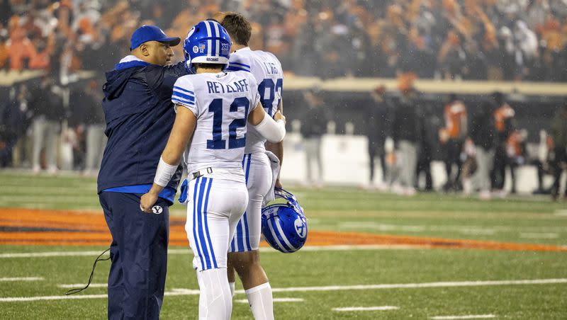 BYU coach Kalani Sitake talks with quarterback Jake Retzlaff (12) and tight end Isaac Rex (83) after the team’s NCAA college football game against Oklahoma State on Saturday, Nov. 25, 2023, in Stillwater, Okla. 