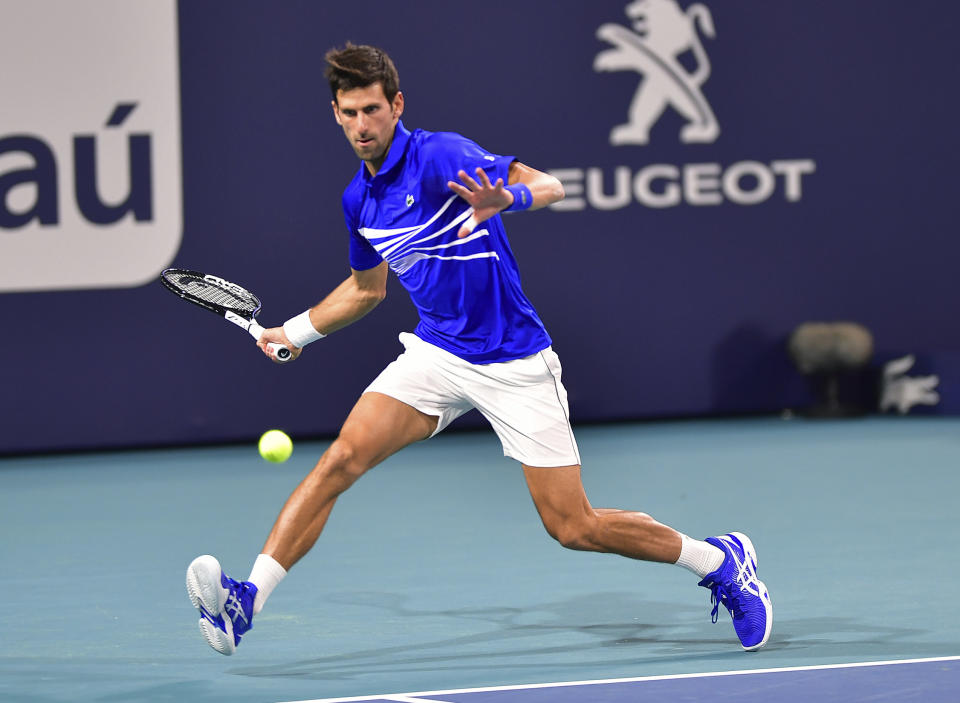 El serbio Novak Djokovic devuelve un tiro de Bernard Tomic, de Australia, durante el Abierto de Miami de tenis, el viernes 22 de marzo de 2019, en Miami Gardens, Florida. (AP Foto/Jim Rassol)