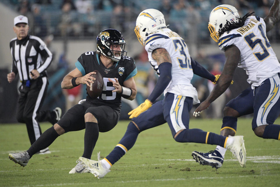 Jacksonville Jaguars quarterback Gardner Minshew, left, looks to pass as he is rushed by Los Angeles Chargers free safety Derwin James, center, and defensive end Melvin Ingram, right, during the second half of an NFL football game, Sunday, Dec. 8, 2019, in Jacksonville, Fla. (AP Photo/Phelan M. Ebenhack)