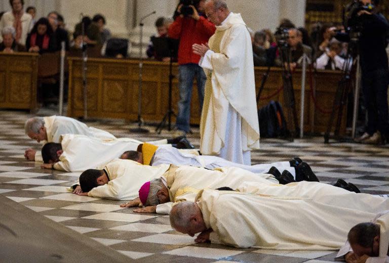 Archbishop of Granada Francisco Javier Martinez (3-R) prostrating himself in a gesture of apology to victims of abuse, on November 23, 2014