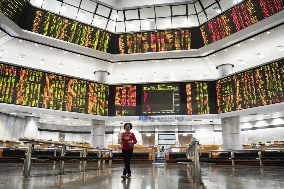 An Investor walks in front of stock trading boards at a private stock market gallery in Kuala Lumpur, Malaysia, Friday, Nov. 30, 2018. Share prices were mixed Friday in Asia ahead of the planned meeting by Presidents Donald Trump of the U.S. and Xi Jinping of China at the Group of 20 summit this weekend. (AP Photo/Yam G-Jun)