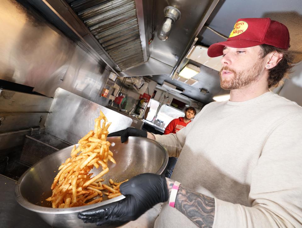 Austin Bickford of Raynham, owner of Augie's Food Truck in Lakeville, makes fries on Saturday, Jan. 27, 2024.