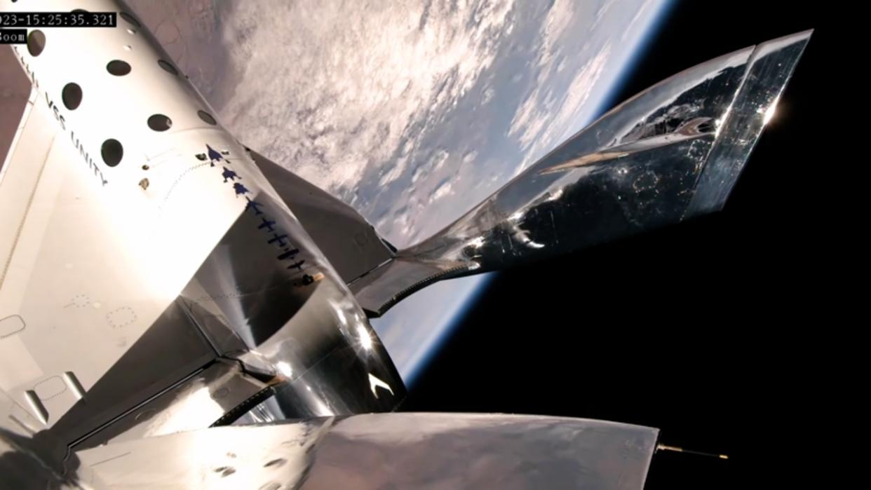  The curvature of Earth can be seen behind a silver spaceplane. 