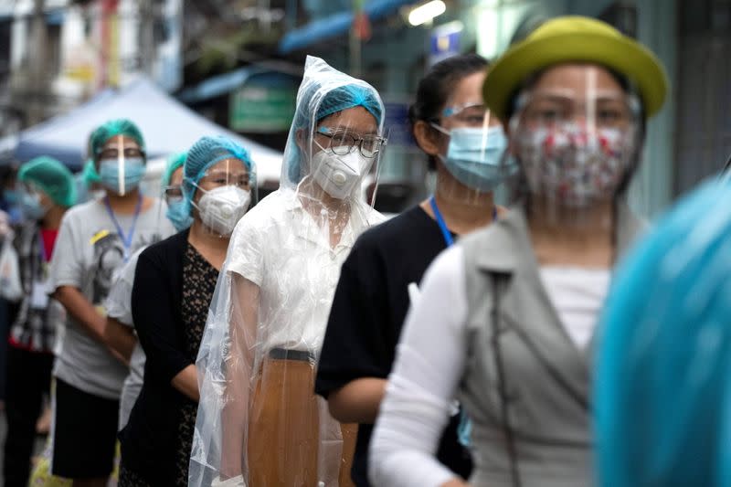 People wearing face masks wait to cast their ballots for the general election at a polling station in Yangon, Myanmar