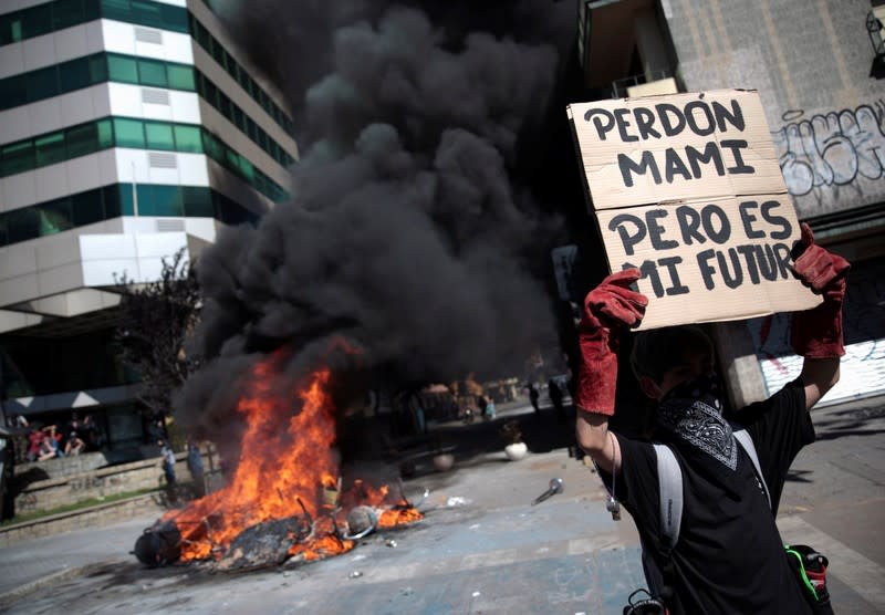 A demonstrator holds up a banner reading 'Sorry Mom, but it is my future' during a protest against Chile's state economic model in Concepcion