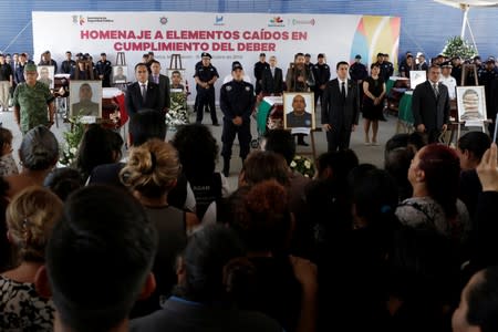 Relatives of a police officer, who was killed along other fellow police officers during an ambush by suspected cartel hitmen, attend an homage organised by the state government, in Morelia