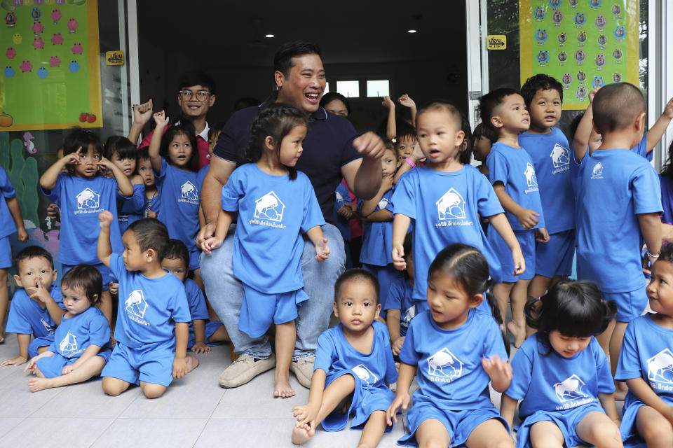 In this photo provided by the Foundation For Slum Child Care, Vacharaesorn Vivacharawongse, center back, visits the daycare center in Bangkok, Thailand, Tuesday, Aug. 8, 2023. The estranged son of Thailand’s King Maha Vajiralongkorn visited the daycare center for underprivileged children in Bangkok on Tuesday following his surprise return to the country after 27 years of living abroad. (Foundation For Slum Child Care via AP)