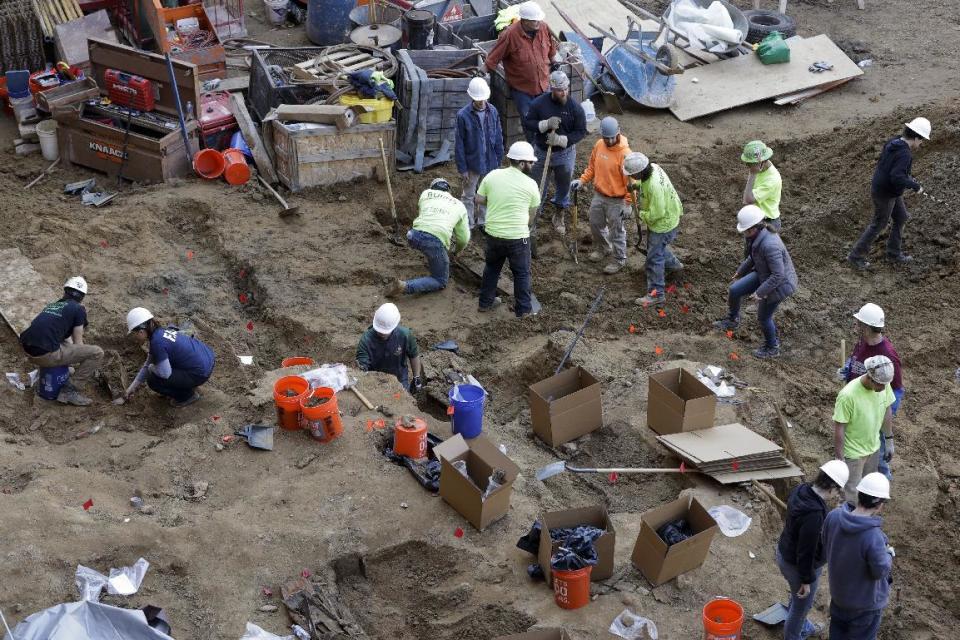 Workers excavate coffins from a construction site in the Old City neighborhood, Thursday, March 9, 2017, in Philadelphia. Crews working on an apartment building in Philadelphia's historic district got a shock last month when their backhoes started hitting coffins and unearthing fully intact human remains. The site was supposed to be a former burial ground from 1707, and all remains were supposedly exhumed in the 1800s and moved to a different cemetery. (AP Photo/Matt Slocum)