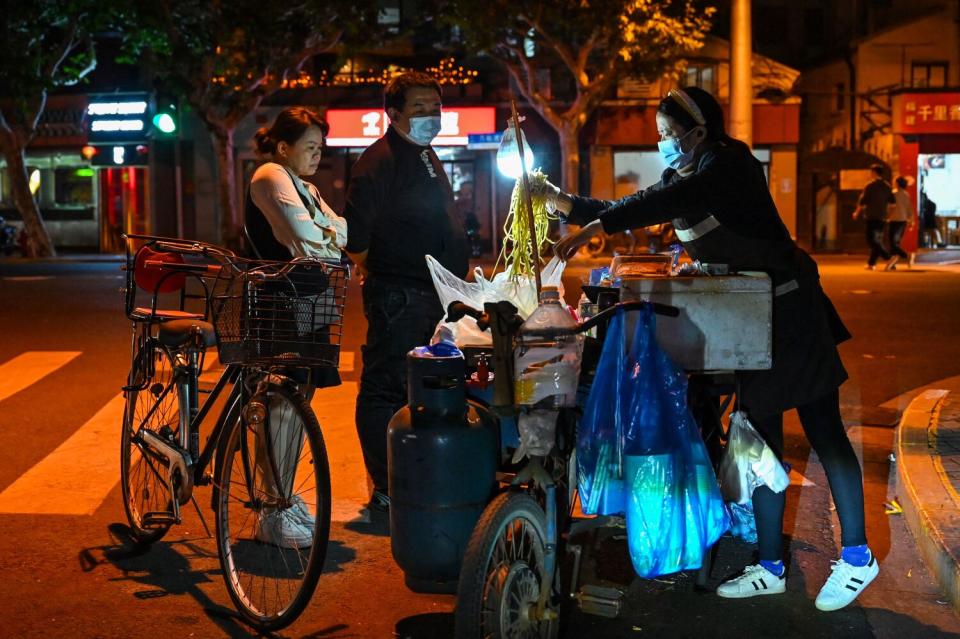 People buying noodles from a street vendor in Shanghai