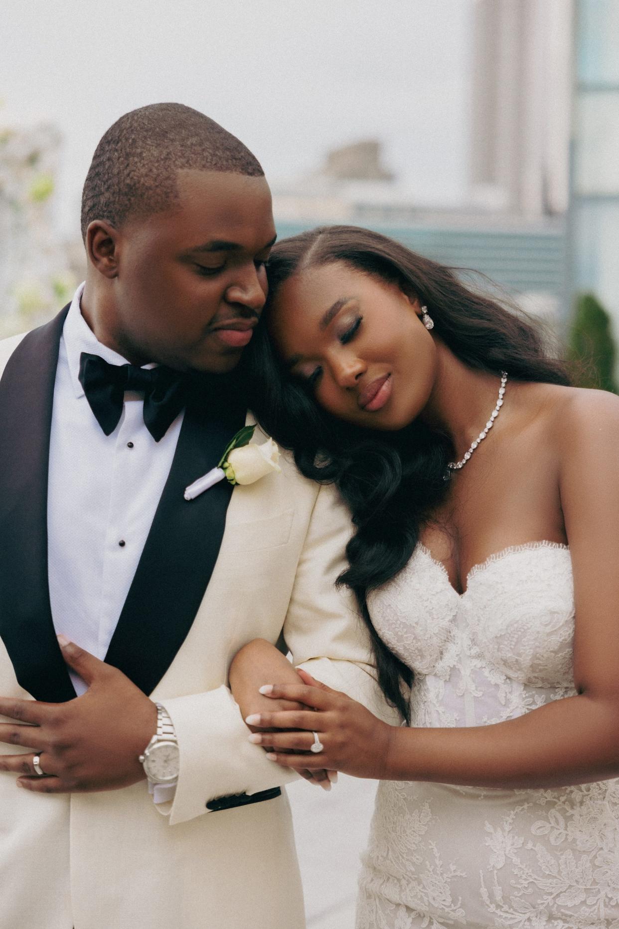 A bride leans her head on her groom's shoulder.