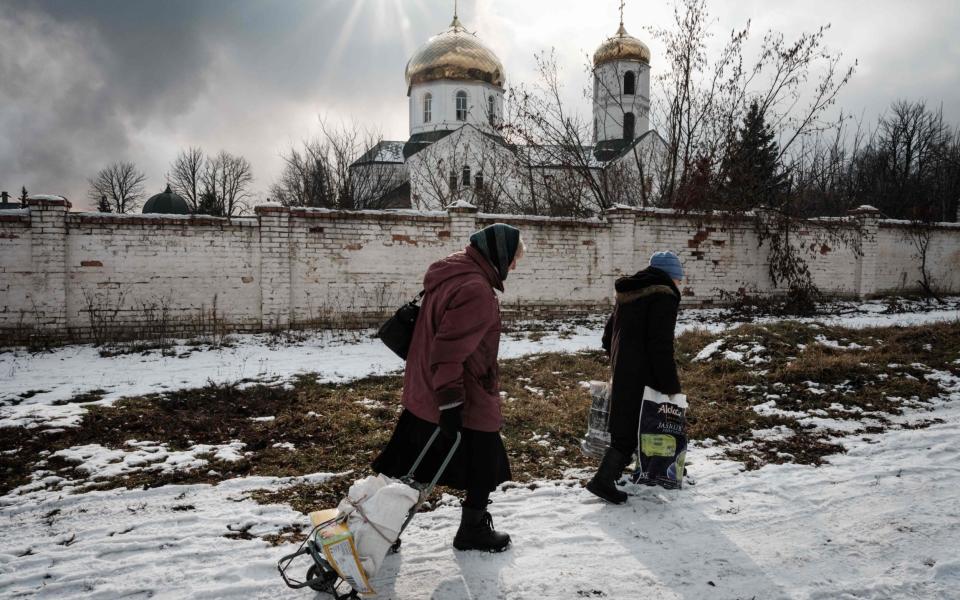 Orthodox Christians leave after the Sunday prayer at the Church of All Saints as sounds and vibrations of shelling continue in Bakhmut - YASUYOSHI CHIBA/AFP