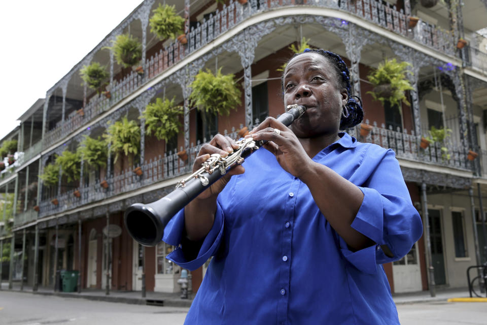 Musician Doreen Ketchens plays her clarinet at the corner of St. Peter and Royal streets in the French Quarter of New Orleans, Wednesday, Aug. 26, 2020. For Ketchens, the coronavirus pandemic is economically much tougher than Hurricane Katrina. When she isn’t touring the world for clarinet concerts, she’s playing in the French Quarter with her husband (sousaphone) and daughter (drums). After Katrina, she could travel for gigs around the country, but that’s not an option now. A once-full calendar has dwindled to nothing. (AP Photo/Rusty Costanza)