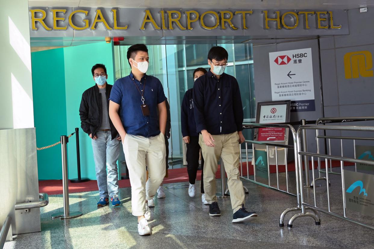 People leave the Regal Airport Hotel at Chek Lap Kok airport in Hong Kong on November 26, 2021, where a new Covid-19 variant deemed a 'major threat' was detected in a traveller from South Africa and who has since passed it on to a local man whilst in quarantine. (Photo by Peter PARKS / AFP) (Photo by PETER PARKS/AFP via Getty Images)