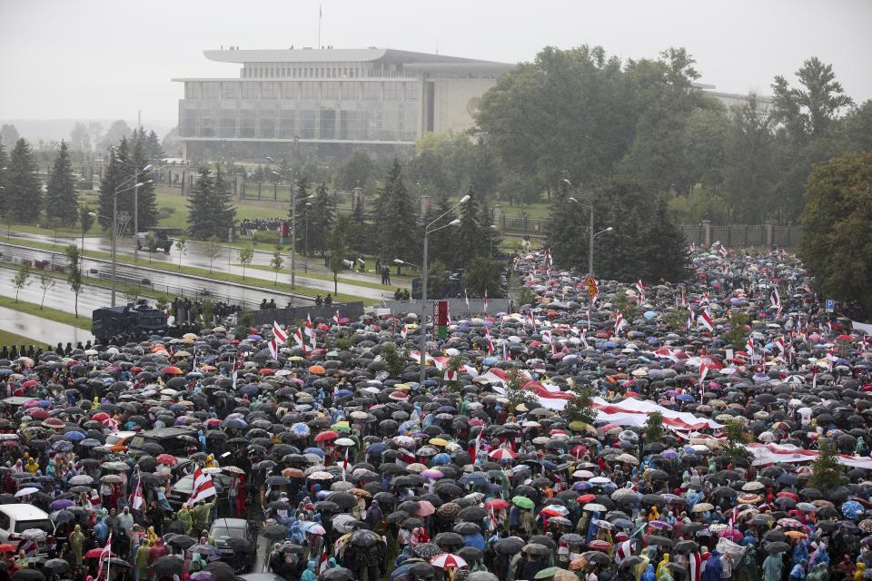 Belarusian opposition supporters gather in front of police line toward the Independence Palace, residence of the President Alexander Lukashenko, in the background, in Minsk, Belarus, Sunday, Sept. 6, 2020. Sunday's demonstration marked the beginning of the fifth week of daily protests calling for Belarusian President Alexander Lukashenko's resignation in the wake of allegedly manipulated elections. (AP Photo/TUT.by)