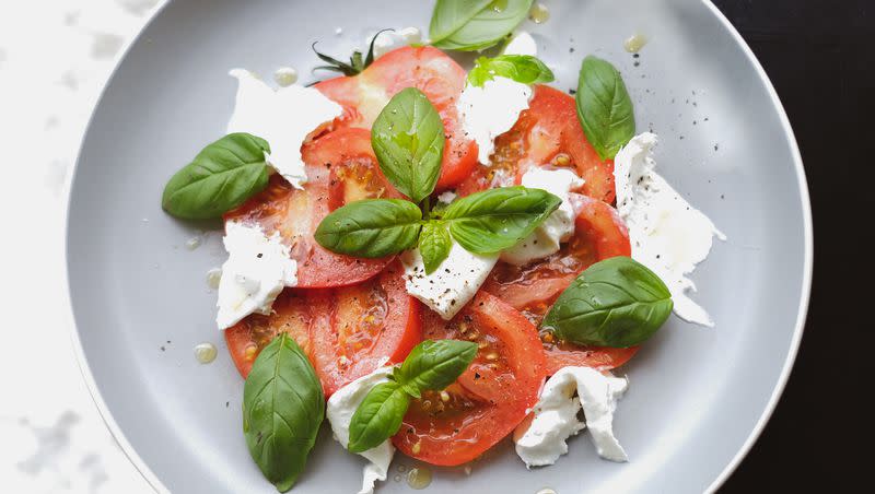 Caprese salad on a gray plate.