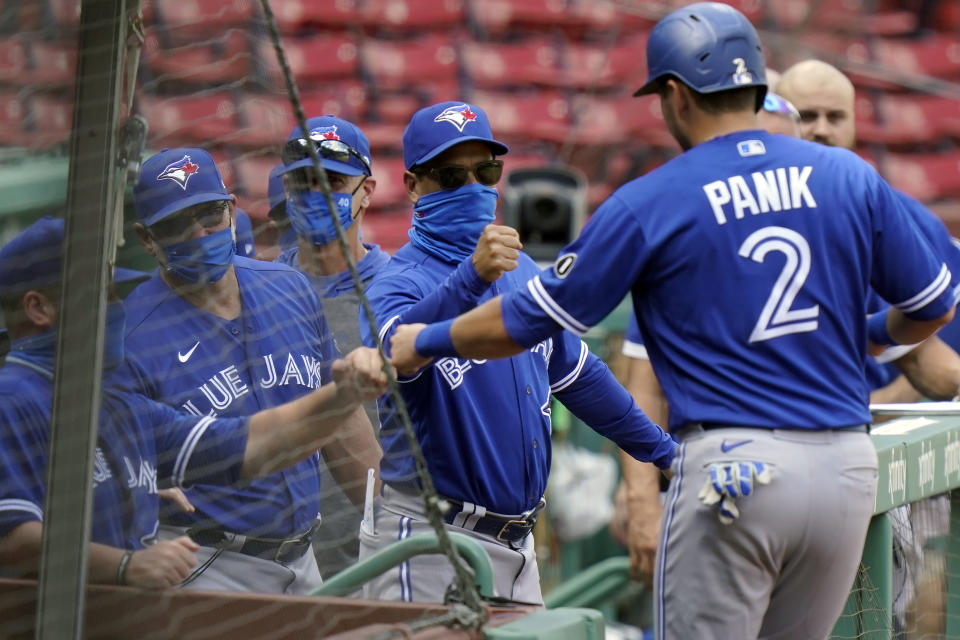 Toronto Blue Jays' Joe Panik (2) is welcomed to the dugout after scoring on a double by Cavan Biggio, not shown, in the fifth inning of a baseball game against the Boston Red Sox, Sunday, Sept. 6, 2020, in Boston. (AP Photo/Steven Senne)