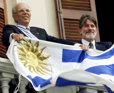 Former President of Uruguay Jorge Batlle (L) and his vice-president, Luis Hierro, wave the country's flag while greeting fans from the balcony of the Independence Palace soon after being sworn in in Montevideo, Uruguay, in this March 1, 2000 file picture. REUTERS/Andres Stapff/File Photo