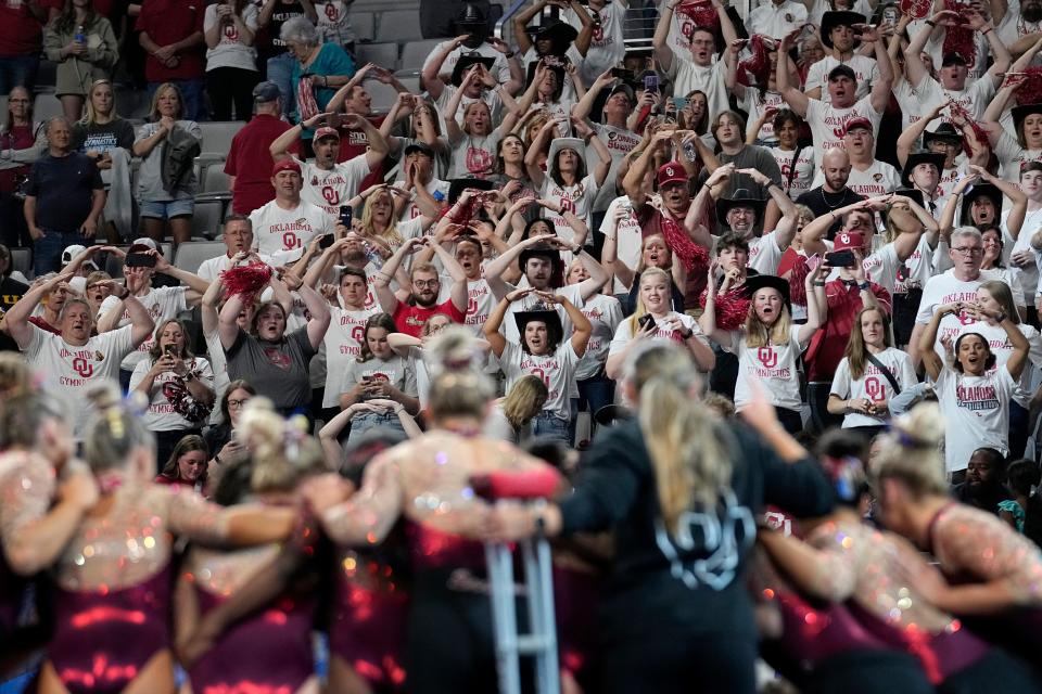 Oklahoma fans cheer on the team, foreground, after Oklahoma won the NCAA women's gymnastics championships team title Saturday, April 15, 2023, in Fort Worth, Texas. (AP Photo/Tony Gutierrez)