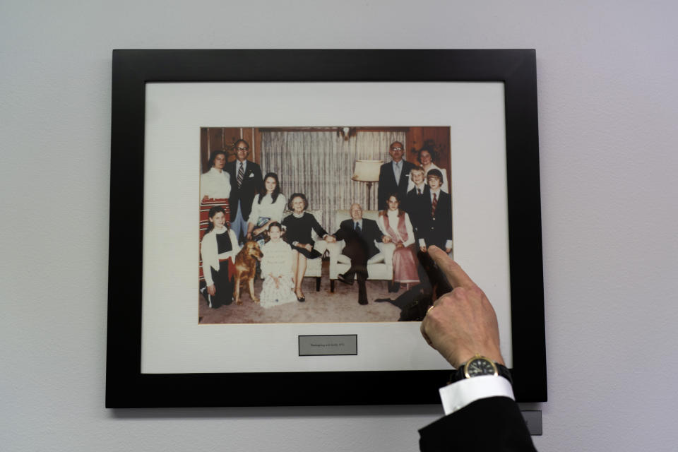 CEO Bill Hahn points to an old family photo of John Birch Society founder, Robert Welch, which hangs in a basement corridor connecting two buildings at their headquarters in Appleton, Wis., Thursday, Nov. 17, 2022. (AP Photo/David Goldman)