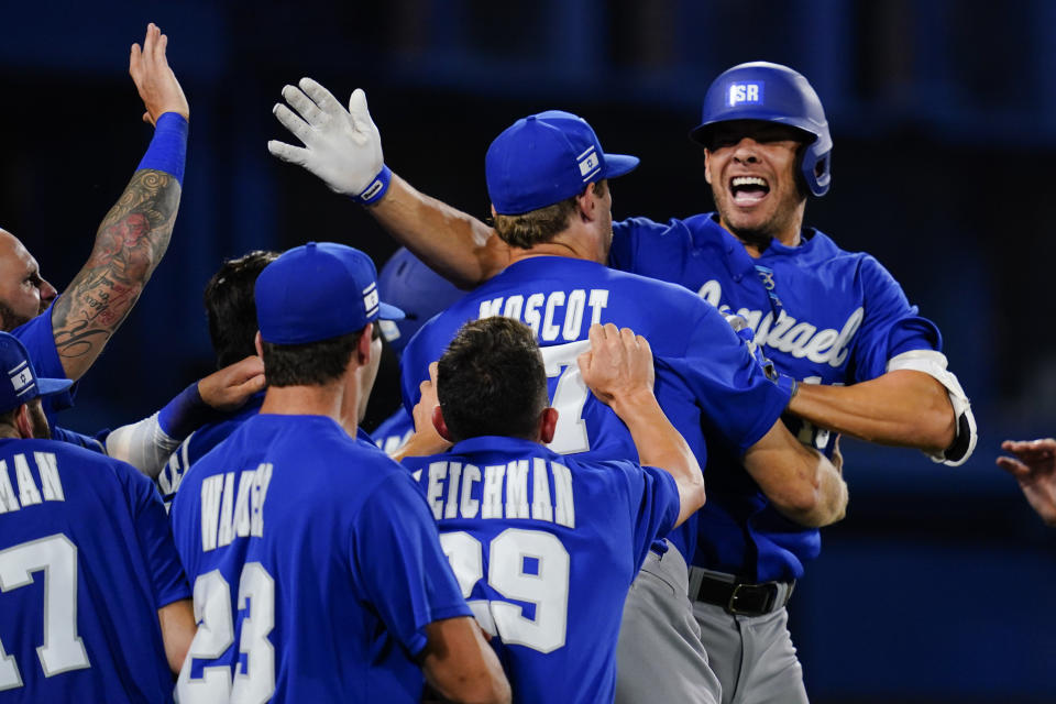 Israel's Danny Valencia, right, celebrate with teammates after hitting a two run home run during the eight inning of a baseball game against the Dominican Republicat at the 2020 Summer Olympics, Tuesday, Aug. 3, 2021, in Yokohama, Japan. (AP Photo/Matt Slocum)
