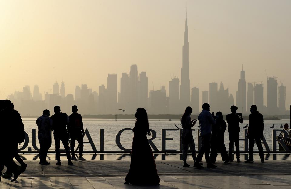 People enjoy their weekend with the view of city skyline and the world tallest tower, Burj Khalifa, in Dubai, United Arab Emirates, Friday, Jan.29, 2021. (AP Photo/Kamran Jebreili)