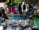 People shop for clothing at the used-clothes market in Baghdad, Iraq, Tuesday, Oct. 20, 2020. Iraq is in the throes of an unprecedented liquidity crisis, as the cash-strapped state wrestles to pay public sector salaries and import essential goods while oil prices remain dangerously low. (AP Photo/Khalid Mohammed)