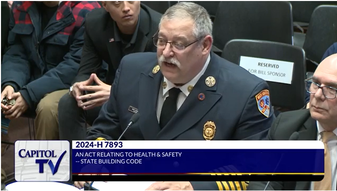 In an image taken from Capitol TV video, North Kingstown Fire Chief Scott Kettelle speaks at a hearing before the House Municipal Government and Housing Committee, saying he has "grave concerns" about a bill that would allow single stairwells in buildings of up to six stories.