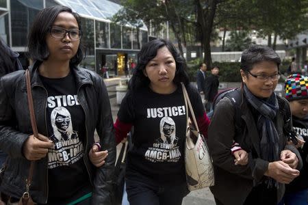 Erwiana Sulistyaningsih (C), a former Indonesian domestic helper, join hands with supporters as she arrives the district court in Hong Kong February 27, 2015. REUTERS/Tyrone Siu