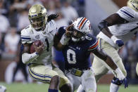 Akron quarterback Kato Nelson (1) escapes the pressure from Auburn linebacker Owen Pappoe (0) during the first half of an NCAA college football game Saturday, Sept. 4, 2021, in Auburn, Ala. (AP Photo/Butch Dill)