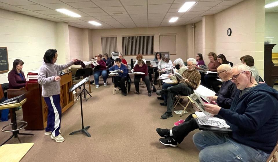 At left, Zing Allsopp, director, and Becky Schrock, accompanist, lead the Greater Johnstown Community Chorus through a song at a recent practice.