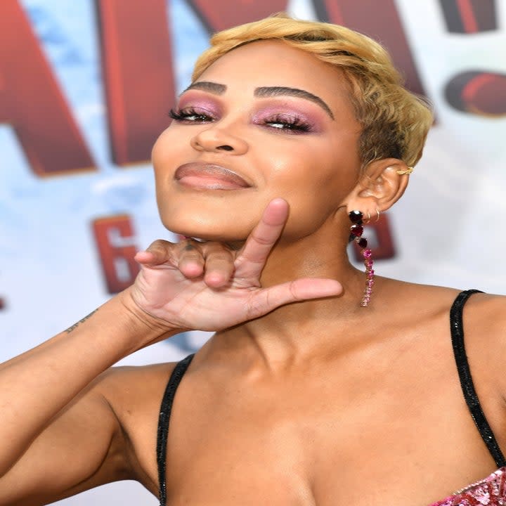 A close-up of Meagan Good posing with her hand under chin for photographers on the red carpet