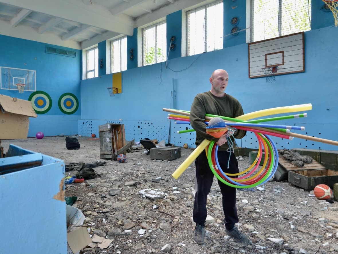 Klizub Artem, a karate instructor in Vilkhivka, Ukraine, on the outskirts of Kharkiv collects sports equipment from the local school that was destroyed during the Russian invasion. (Murray Brewster/CBC - image credit)