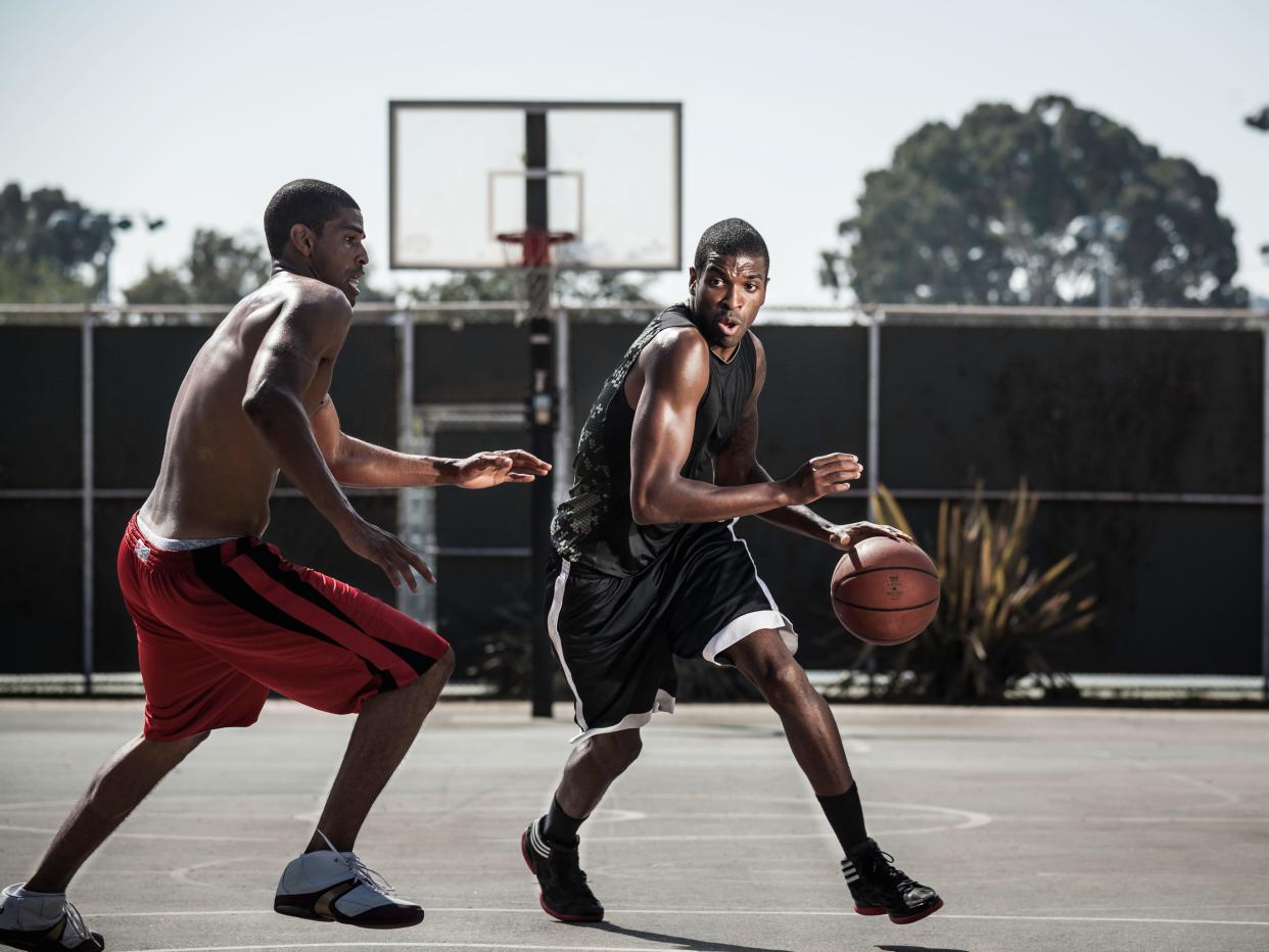 Two people playing basketball