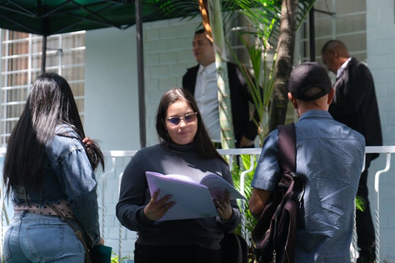 People wait to be called inside with their documents at the new Venezuelan consulate in Medellin, Colombia, on Tuesday. Appointments must first be booked online. Photo by Austin Landis/UPI